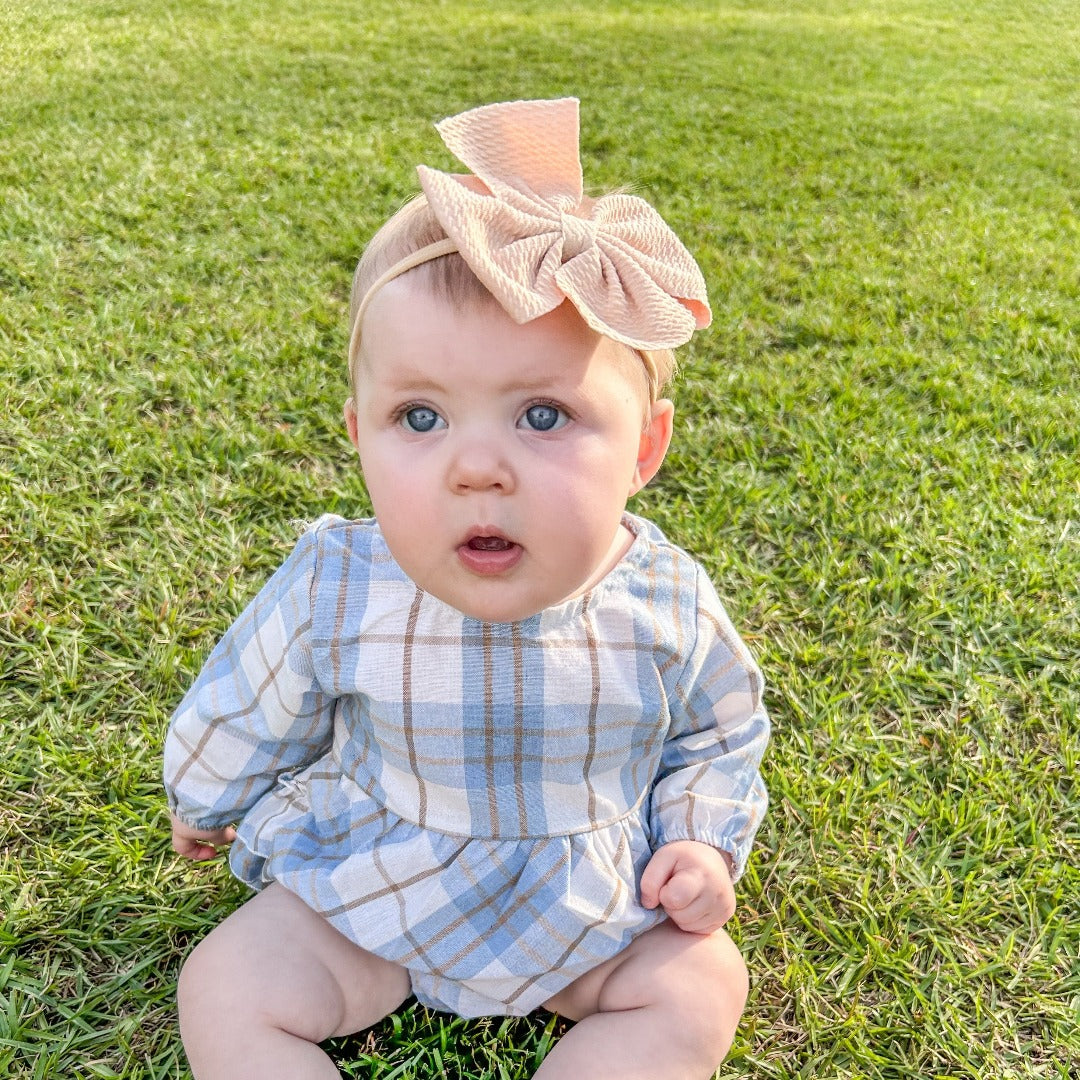 Girls' Pretty in Plaid Ruffles: A long-sleeve onesie with a light blue plaid pattern and ruffles.