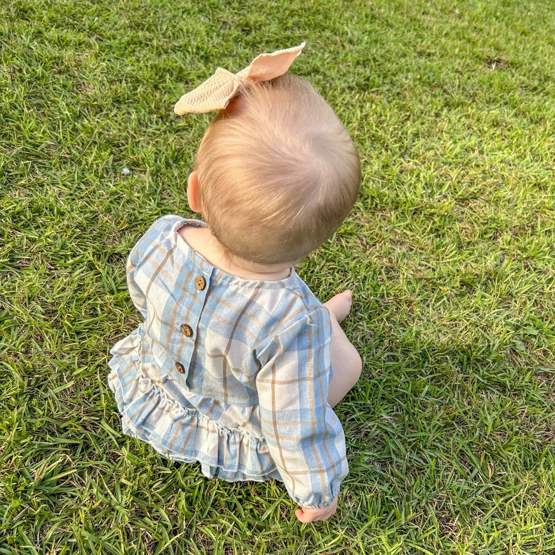 Girls' Pretty in Plaid Ruffles: A long-sleeve onesie with a light blue plaid pattern and ruffles.