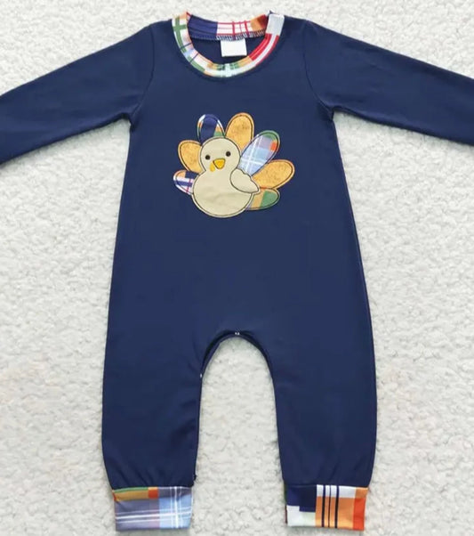 "Boys' Turkey Trot Onesie: A jumper-style navy blue outfit with a turkey design on the front, accented with plaid trim.